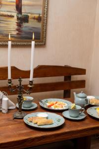NizhnedneprovskЕДБУРГ Готельно-ресторанний комплекс的一张桌子,上面放着食物和蜡烛