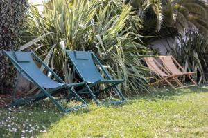 滨海拉库阿尔德珀尔德热公寓式酒店的两把蓝色草坪椅,坐在草地上