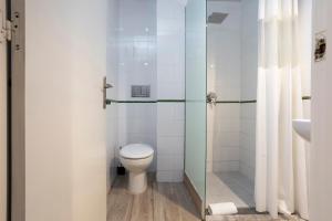 巴塞罗那HOSTAL BEDMATES的一间带卫生间和玻璃淋浴间的浴室
