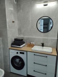 波兹南STARA CEGIELNIA, Faktura VAT, bezkontaktowe zameldowanie的一间带洗衣机和镜子的浴室