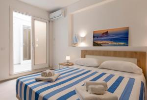 马里迪莫Tenuta Pezzeselle - Casa Vacanze的卧室配有蓝色和白色条纹床和2条毛巾