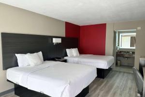 可可Ramada by Wyndham Cocoa的红色墙壁的酒店客房内的两张床
