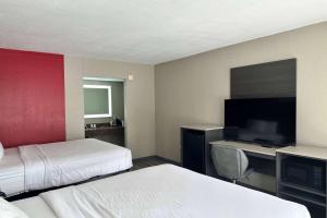 可可Ramada by Wyndham Cocoa的酒店客房设有两张床和一台平面电视。