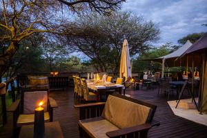龙杜Taranga Safari Lodge的一个带桌椅和遮阳伞的庭院
