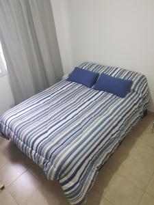 布宜诺斯艾利斯Jazzy-Habitación en Dpto Compartido的卧室内的一张带蓝色枕头的床