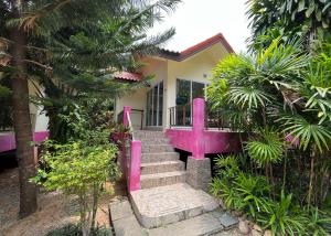 拉迈Mae Somboon House的粉红色的房子,前面有楼梯