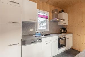 穆劳Feriendorf Murau by ALPS RESORTS的白色的厨房配有白色橱柜和窗户