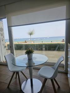 圣安东尼奥·德·卡隆Mar Vista的一张玻璃桌、两把椅子和一张桌子,享有海滩美景