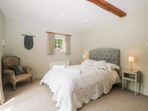 佩特沃斯Hungers Cottage的一间卧室配有一张大床和一把椅子