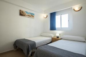 贝尼多姆托雷亚戈公寓酒店的带窗户的客房内的两张床