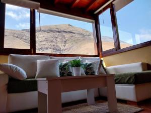 亚伊萨Finca Esperanza的带沙发、桌子和窗户的客厅