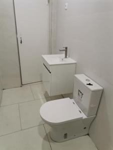 普拉亚Homing Plateau - Apartment in the city of Praia的白色的浴室设有卫生间和水槽。