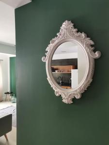 普拉亚Homing Plateau - Apartment in the city of Praia的客房内绿色墙上的白色镜子
