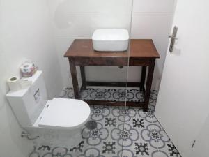 普拉亚Homing Plateau - Apartment in the city of Praia的一间带卫生间和木桌的浴室