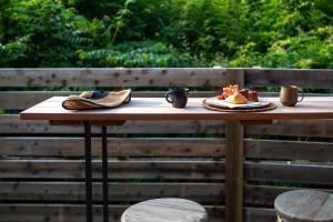 轻井泽Hutte Gartenland -KAIZUKA- ヒュッテ ガーテンラント カイヅカ的一张带鞋子和一盘食物的木桌