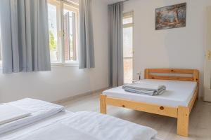 塞格德Barát Vendégház - Cosy Guesthouse - Teljes ház privát udvarral - 4 szoba, 2 fürdő的一间卧室设有两张床和窗户。