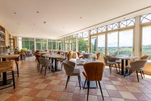 圣日的贡桑斯城堡酒店的餐厅设有桌椅和窗户。