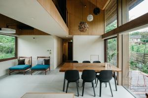 轻井泽Hutte Gartenland -KAIZUKA- ヒュッテ ガーテンラント カイヅカ的一间带木桌和椅子的用餐室