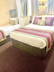 布莱克浦伯翰姆伍德法院酒店的酒店客房设有两张床和窗户。