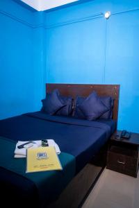 古瓦哈提Shree Krishna GH的蓝色的房间,床上标有标志