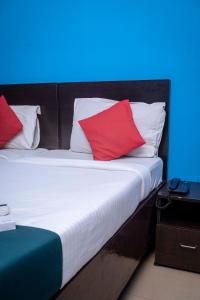 古瓦哈提Shree Krishna GH的一张带红色和白色枕头的床