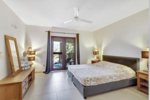克拉伦代克Bonaire Apartment的一间卧室设有一张床,并有通往阳台的门