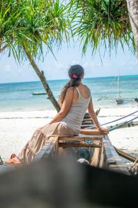 江比阿Ladha ya Zanzibar Boutique Guesthouse的坐在海滩上船上的女人