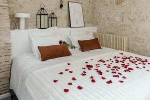 沙托鲁My Home Prestige / SPA Privatif的一张白色的床,上面有红玫瑰