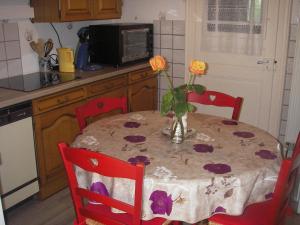 Masevauxgite violette et pierrot的厨房配有一张桌子,上面放着花瓶