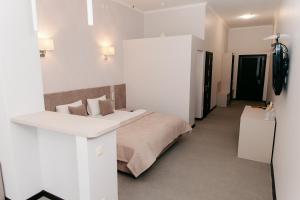 赫梅利尼茨基СПА Готель СВ的白色卧室配有床和书桌