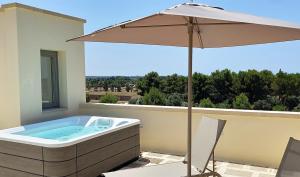 加利波利Torre Assunta Masseria的庭院内带遮阳伞的热水浴池