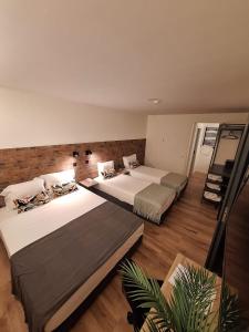波尔图Hotel Portucalense的大客房铺有木地板,配有两张床。