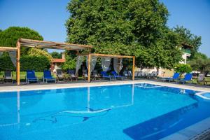 沃尔沃罗Villa Vasiliadi的一个带蓝色椅子和天篷的大型游泳池