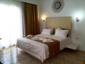 卡马利阿塔洛斯套房公寓式酒店的一间卧室配有一张大床和毛巾