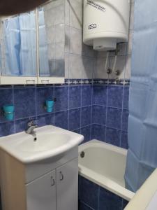 大格拉迪什泰Dunav 009的蓝色瓷砖浴室设有水槽和卫生间