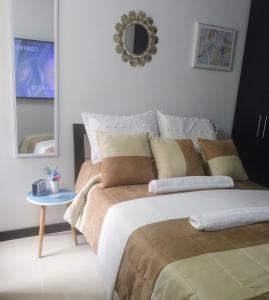 波哥大Apartamento sector exclusivo acogedor的一间卧室配有带枕头和镜子的床