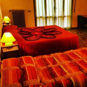 比萨B&B Francesco的一间卧室配有两张带红色床罩和灯的卧室