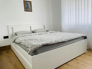 希奥利艾Alto Turtas Apartamentai的白色卧室内的白色床,设有白色墙壁