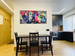 希奥利艾Alto Turtas Apartamentai的餐桌、椅子和墙上的绘画