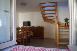 LugnyLa maison de Michelle的客房设有楼梯、桌子和电视。