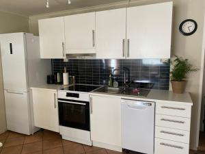 特罗姆瑟WALO APARTMENTS Tromsø - Alfheim 10 min walk to city centre - No parking的厨房配有白色橱柜和水槽