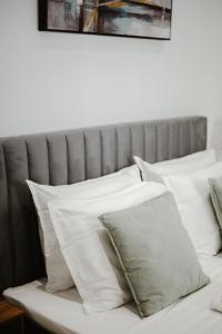 沃洛斯M & N Guesthouse的床上的一堆白色枕头