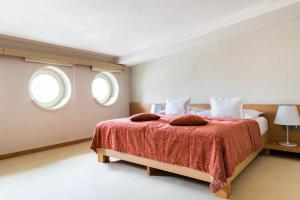 布拉迪斯拉发Roset Hotel & Residence的一间卧室设有一张大床和两个窗户