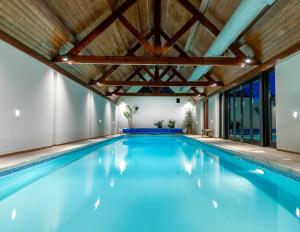 Potter Street5 Bed Farmhouse Suitable for Contractors Private Parking的一个带木制天花板的大型游泳池