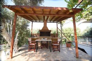 普洛马里翁Villa Eirini Agia Varvara Lesvos的庭院内带桌椅的木制凉亭