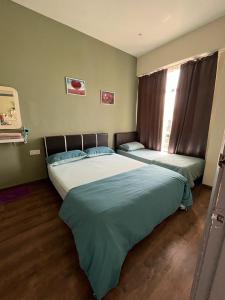 马六甲Homestay Melaka Mahkota Melaya Raya的一间卧室设有两张床和窗户。