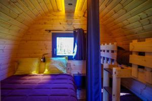 LugnyDomaine Joseph LAFARGE Wine Resort Oeno-tonneaux expérience的小木屋内一间卧室,配有一张床