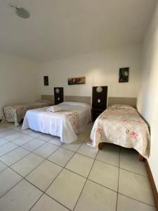 卡纳内亚Hotel Sol A Sol的客房设有两张床,铺有瓷砖地板。
