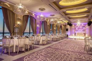 安曼Harir Palace Hotel的宴会厅配有桌椅和吊灯