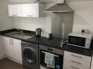 米德尔斯伯勒Alphalink Apartment的厨房配有微波炉、洗衣机和烘干机